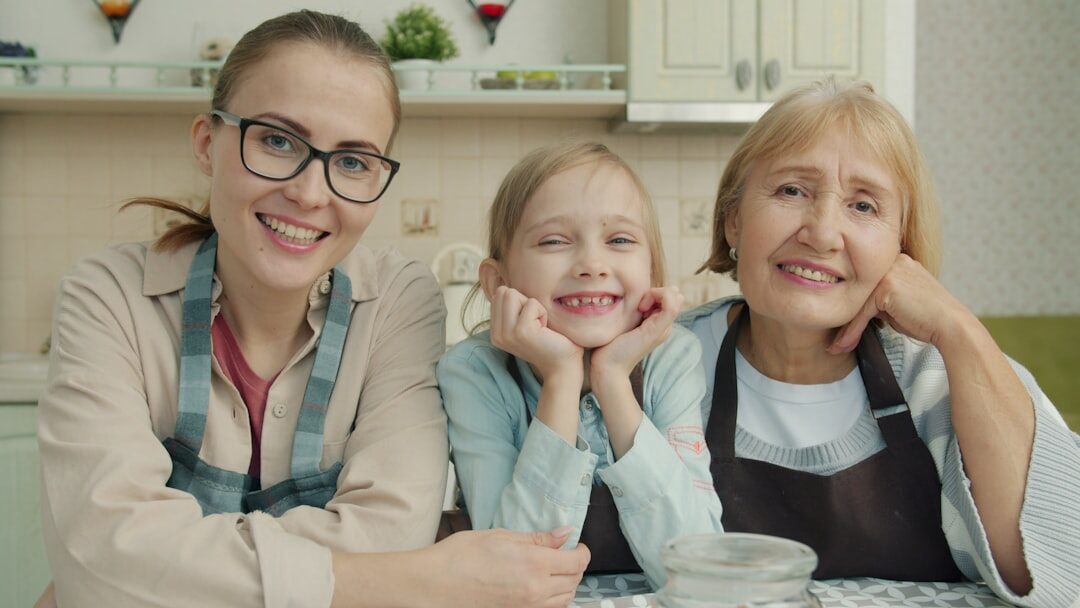 Three generations of a family sitting together at home